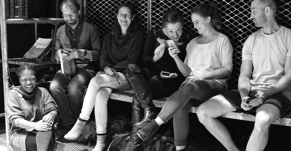A group of people relaxing offstage during rehearsals