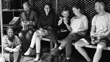 A group of people relaxing offstage during rehearsals