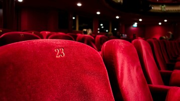 Red theatre seats with gold embroidered numbers