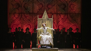 Elizabeth I sitting on throne surrounded by chorus