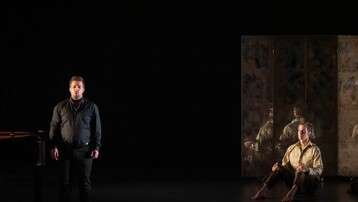 Singer standing whilst dancer is seated