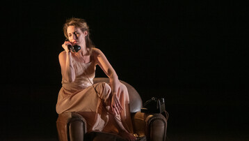 Woman sat on armchair arm on a rotary phone