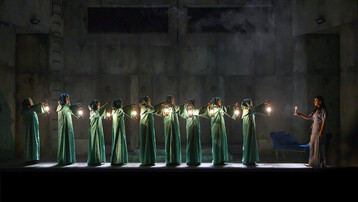 Line of witches with lanterns watching Lady Macbeth sleepwalk